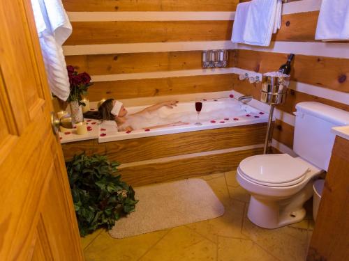 赛维尔维尔Rustic Cabin的男人躺在浴室的浴缸里