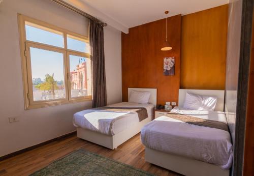 a bedroom with two beds and a window at Museum Plaza in Cairo