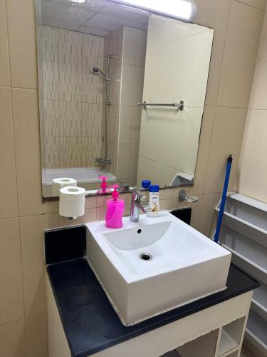 a bathroom with a white sink and a mirror at sweet home 2 BHK apartment in Ajman 