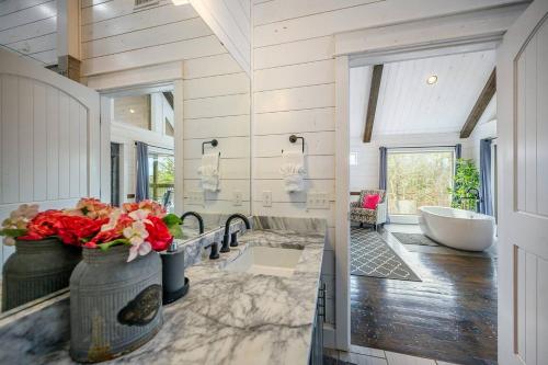 a bathroom with a tub and a sink and a bath tub at Magnolia Peak By The Cohost Company in Broken Bow