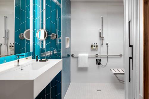 a bathroom with a white sink and blue tiles at Humaniti Hotel Montreal, Autograph Collection in Montréal