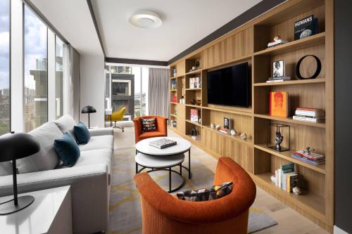 a living room with a couch and a table and chairs at Humaniti Hotel Montreal, Autograph Collection in Montréal