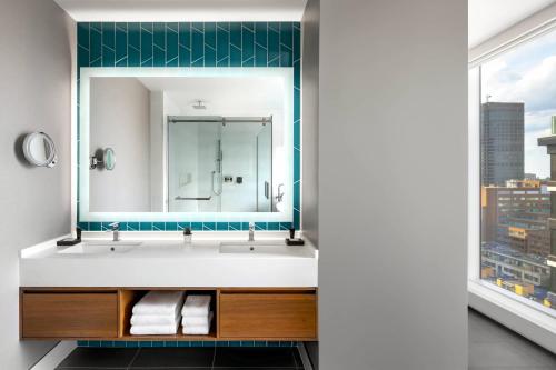 a bathroom with a sink and a mirror at Humaniti Hotel Montreal, Autograph Collection in Montréal