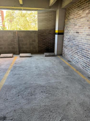 an empty parking garage with a brick wall at Grandioso apartaestudio muy cerca a Provenza 201 in Medellín