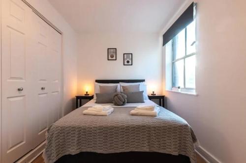 a bedroom with a bed with two towels on it at Southampton Haven in Southampton