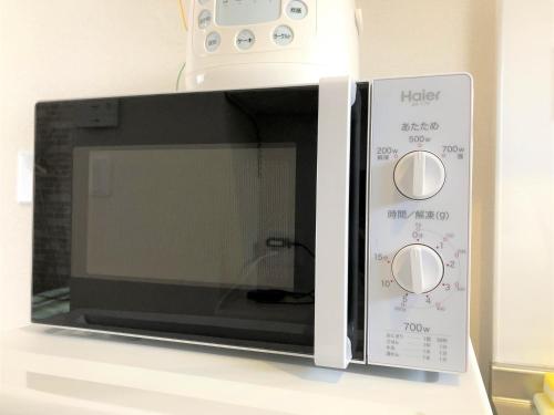 a microwave oven sitting on top of a counter at 所沢駅徒歩10分の閑静なワンルーム ベルーナドーム 東京 川越観光拠点に コンビニ徒歩3分 in Tokorozawa