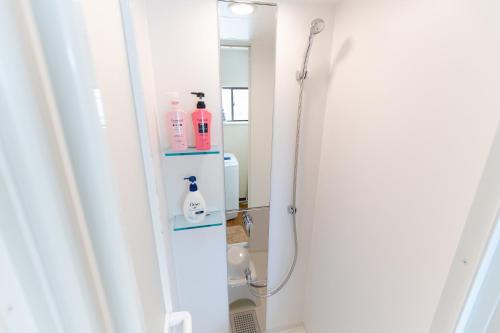a bathroom with a shower with a mirror at 所沢駅徒歩10分の閑静なワンルーム ベルーナドーム 東京 川越観光拠点に コンビニ徒歩3分 in Tokorozawa