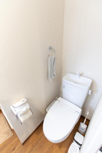 a bathroom with a white toilet with a phone at 所沢駅徒歩10分の閑静なワンルーム ベルーナドーム 東京 川越観光拠点に コンビニ徒歩3分 in Tokorozawa