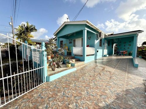 a blue house with a fence in front of it at ZenBreak Steps to the Sea 3Bd in Saint Peter