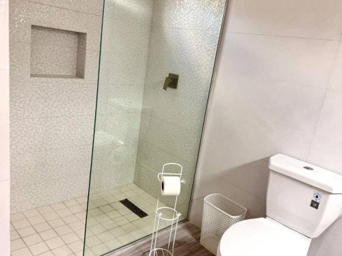 a bathroom with a toilet and a glass shower at ZenBreak Steps to the Sea 3Bd in Saint Peter