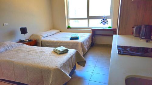 a hotel room with two beds and a window at Depto Apart Hotel Atenea Centro Temuco in Temuco
