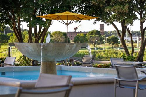 a fountain with chairs and a table with an umbrella at South Sioux City Marriott Riverfront in South Sioux City