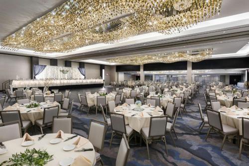 a banquet hall with white tables and chairs and chandeliers at South Sioux City Marriott Riverfront in South Sioux City