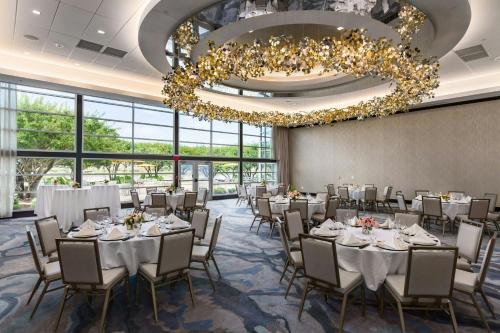 a banquet room with tables and chairs and a chandelier at South Sioux City Marriott Riverfront in South Sioux City