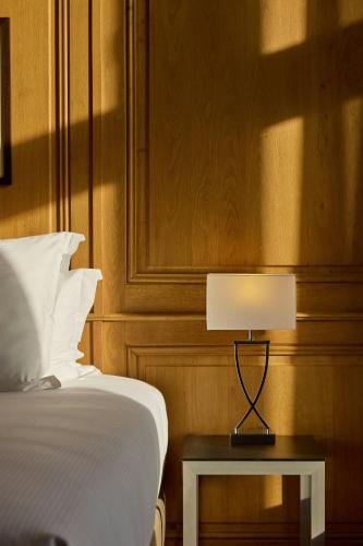 a bedroom with a bed and a table with a lamp at Hôtel de Bourgtheroulde, Autograph Collection in Rouen