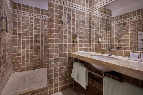 a bathroom with a sink and a shower at Hôtel de Bourgtheroulde, Autograph Collection in Rouen