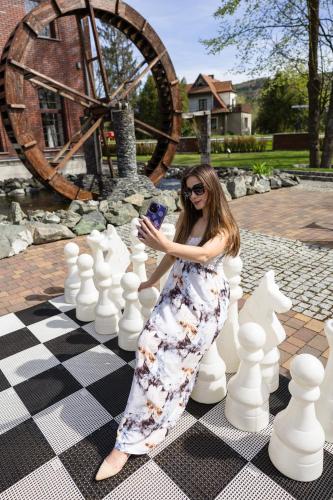 a woman is standing on a giant chessboard at Młyn Jacka Hotel & Spa in Wadowice
