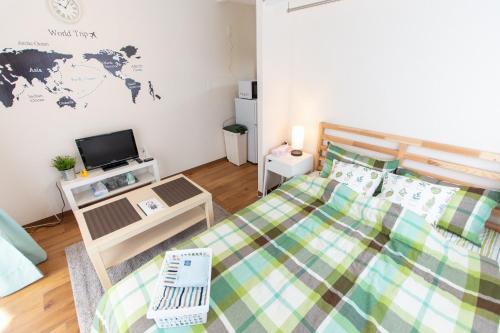 a small bedroom with a bed and a tv at 所沢駅徒歩10分の閑静なワンルーム ベルーナドーム 東京 川越観光拠点に コンビニ徒歩3分 in Tokorozawa
