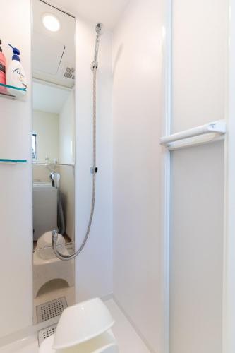 a bathroom with a shower and a toilet at 所沢駅徒歩10分の閑静なワンルーム ベルーナドーム 東京 川越観光拠点に コンビニ徒歩3分 in Tokorozawa