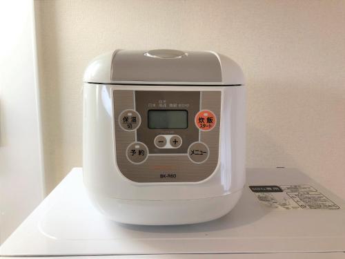 a white appliance sitting on top of a shelf at 所沢駅徒歩10分の閑静なワンルーム ベルーナドーム 東京 川越観光拠点に コンビニ徒歩3分 in Tokorozawa