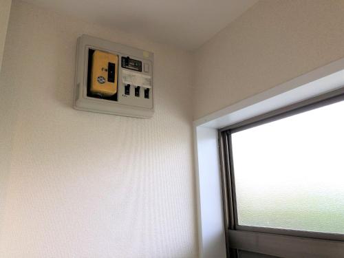 a room with a television on a wall with a window at 所沢駅徒歩10分の閑静なワンルーム ベルーナドーム 東京 川越観光拠点に コンビニ徒歩3分 in Tokorozawa
