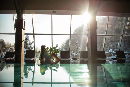 a woman sitting in a pool in a hotel at Młyn Jacka Hotel & Spa in Wadowice