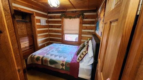 a small room with a bed in a log cabin at Rustic Cabin in Sevierville