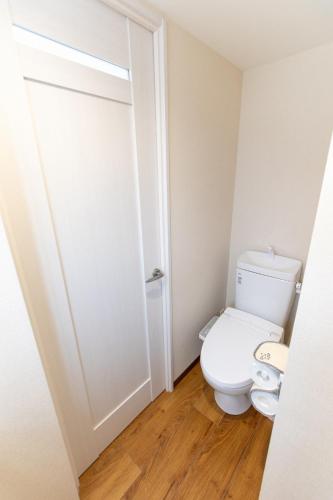a bathroom with a toilet and a door at 所沢駅徒歩10分の閑静なワンルーム ベルーナドーム 東京 川越観光拠点に コンビニ徒歩3分 in Tokorozawa