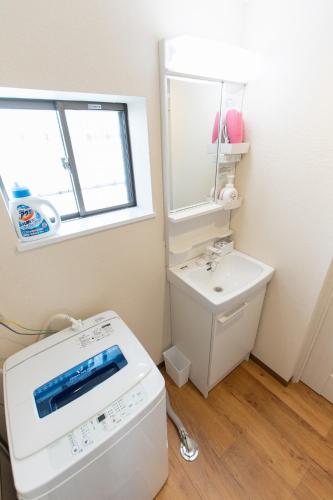 a bathroom with a washing machine and a sink at 所沢駅徒歩10分の閑静なワンルーム ベルーナドーム 東京 川越観光拠点に コンビニ徒歩3分 in Tokorozawa