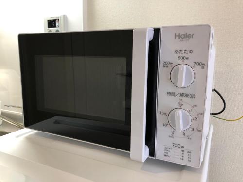 a microwave oven sitting on top of a table at 所沢駅徒歩10分の閑静なワンルーム ベルーナドーム 東京 川越観光拠点に コンビニ徒歩3分 in Tokorozawa
