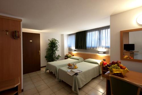 una camera d'albergo con letto e tavolo di Hotel Roma a Cassano Magnago