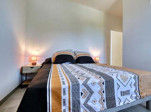 - une chambre avec un lit et une couette blanche et noire dans l'établissement Maison Rénovée, Vue sur Nature, à Fontanès