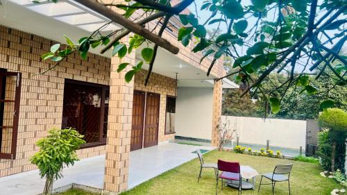 a patio of a house with chairs and a yard at The Lawn House : 3BHK Furnished Villa with Lawn in Amritsar