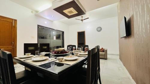 a dining room with a table with dishes on it at The Lawn House : 3BHK Furnished Villa with Lawn in Amritsar