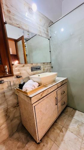 a bathroom with a sink and a large mirror at The Lawn House : 3BHK Furnished Villa with Lawn in Amritsar