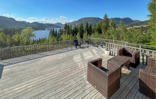 a wooden deck with two chairs and a view of a lake at 5 Bedroom Pet Friendly Home In Eiken in Eiken