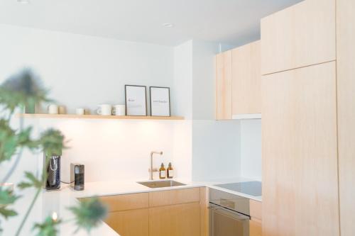a kitchen with wooden cabinets and a sink at clea flims - wandern, biken und stilvoll entspannen in Flims