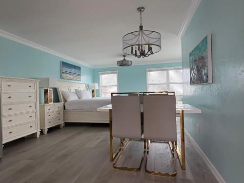 a bedroom with a bed and a table and a chandelier at Flamingo Inn in Fort Myers Beach
