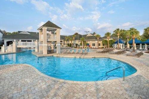 a pool at a resort with tables and chairs at Sheraton Broadway Resort Villas in Myrtle Beach