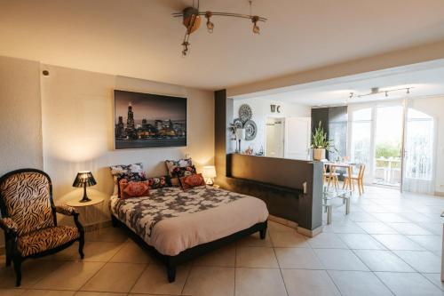 une chambre avec un lit et une salle à manger dans l'établissement Panorama Dream Annecy, Appart 42 m2 avec terrasse abritée, piscine et parking à 10 min d'Annecy, à Poisy