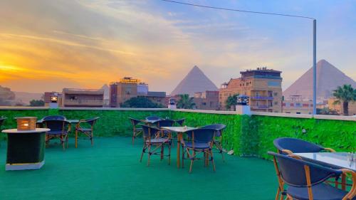a group of tables and chairs on a balcony with pyramids at ATLAS pyramids VIEW in Cairo
