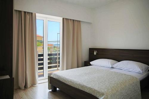 a bedroom with a bed and a large window at Apartments Božena in Vodice