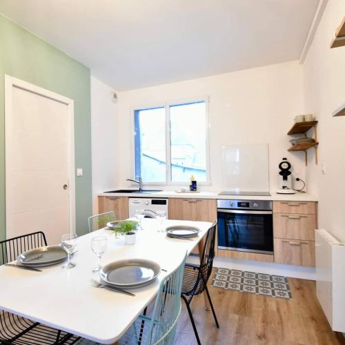 a kitchen with a white table and chairs in it at Opaline - centre-ville in Pontivy
