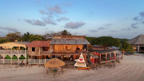 a building on the beach with tables and chairs at Hostel Capitão da Ilha in Algodoal
