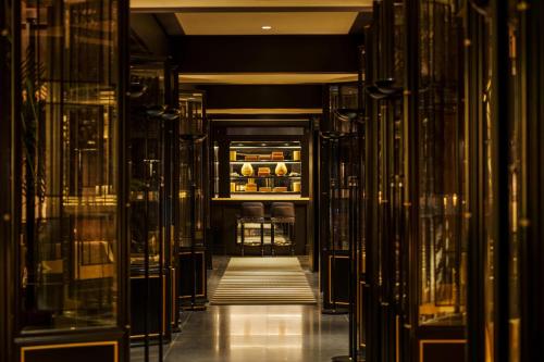 a hallway with glass doors and a refrigerator at Duxton Reserve Singapore, Autograph Collection in Singapore