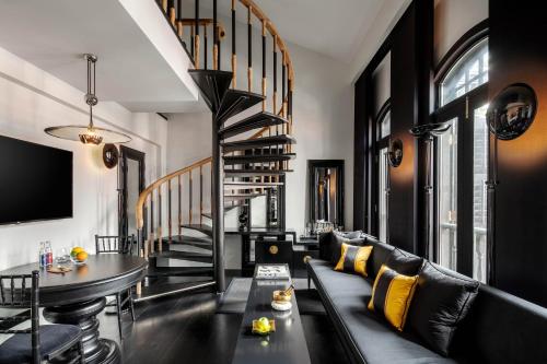 a living room with a couch and a spiral staircase at Duxton Reserve Singapore, Autograph Collection in Singapore