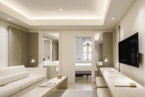 a living room with a white couch and a tv at Duxton Reserve Singapore, Autograph Collection in Singapore