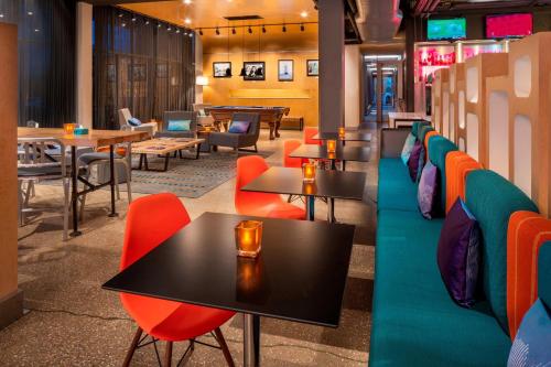 a restaurant with colorful chairs and tables and tables at Aloft Hotel Rogers Bentonville in Rogers