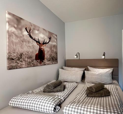 a bedroom with two beds and a picture of a deer at The Lodge Braunlage in Braunlage