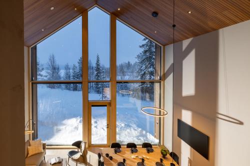 a large window in a room with a table and chairs at Joikun Lumo by Hi Ylläs in Äkäslompolo